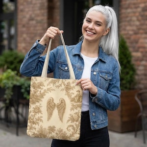 Vintage toile tote bag with angel wings and beige botanical print, rustic French country tote in vintage cottagecore style.