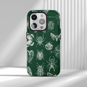 Könnte beinhalten: Eine dunkelwaldgrüne Smartphone-Hülle mit einem sich wiederholenden weißen Linienmuster aus verschiedenen Insekten, darunter Käfer, Motten und Schmetterlinge, die über die gesamte Rückseite der Schutzhülle verteilt sind.