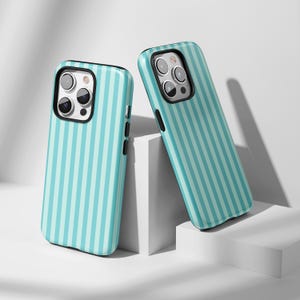 May include: Two teal and white striped phone cases. The cases have a black border around the camera and a black side button. The cases are leaning against a white background.