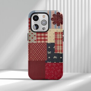 May include: A patchwork phone case with a mix of patterns and textures. The design incorporates red hearts, plaid, floral, and striped elements. A large, dark red flower is on the upper right. The case has a dark red border.