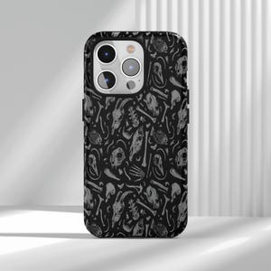 May include: Black phone case with a repeating pattern of gray animal skulls, bones, and fish skeletons. The case has a glossy finish and a camera cutout. The design is a macabre, yet artistic, pattern.