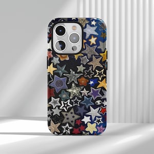 Peut inclure: Coque de téléphone ornée d'un motif d'étoiles multicolores, notamment bleu, jaune, rouge et argent. Les étoiles, de tailles et textures variées, créent un design texturé et attrayant. Le contour de la coque est noir.