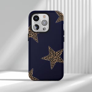 May include: A navy blue phone case featuring a pattern of leopard print stars. The case has a glossy finish and a black border. The camera lenses are visible at the top.