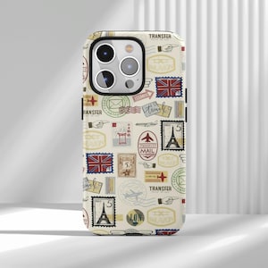May include: A phone case with a cream background, decorated with a collage of vintage postage stamps and travel-themed graphics. The design includes stamps with the Eiffel Tower, Union Jack flags, and the text "TRANSFER".