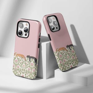 May include: Two pink phone cases with a floral design and sleeping cats. One case features an orange tabby cat and a black cat, while the other has a black cat and an orange tabby cat. The cases have black borders.