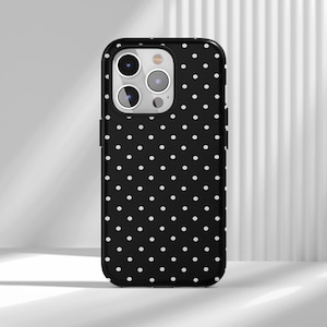 May include: Black phone case with a white polka dot pattern. The case has a glossy finish and a camera cutout. The phone case is designed to fit a smartphone.