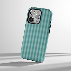 May include: A teal and light blue striped phone case. The case has a black border around the camera and buttons. The case is designed to fit a smartphone.