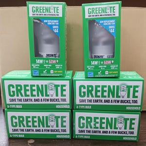 May include: Several boxes of GREENLITE A-Type household light bulbs. The boxes are green and white, with the brand name and energy-saving information. The boxes show the light bulb and state that it saves $44. The bulbs are 14W and equivalent to 60W.