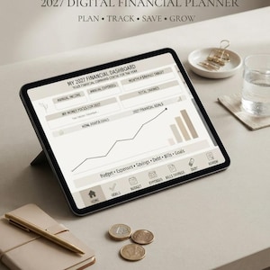 May include: A digital tablet displaying a 2027 financial planner dashboard with sections for annual income, expenses, savings targets, and a line graph for financial goals. The screen includes navigation icons for home, goals, budget, expenses, bills, savings, and debt.