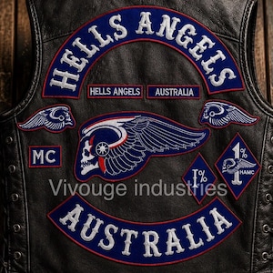 May include: A black leather vest featuring embroidered patches with the text HELLS ANGELS, AUSTRALIA, MC, and 1%. The back displays a large winged skull emblem in blue, white, and red, with smaller winged skull patches and diamond-shaped 1% insignias.