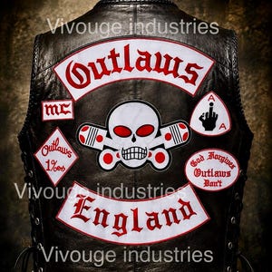 Könnte beinhalten: Eine schwarze Lederweste mit gestickten Aufnähern, darunter ein zentraler Totenkopf mit gekreuzten Kolben, die Schriftzüge Outlaws, England, MC, 1% und God Forgives Outlaws Don't sowie ein Aufnäher mit einer Handgeste auf weißem Grund.