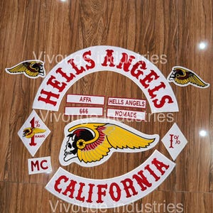 May include: A set of embroidered patches featuring the text HELLS ANGELS and CALIFORNIA in red on white backgrounds. Includes a large winged skull emblem, two diamond-shaped 1% patches, two small winged skull patches, and rectangular labels reading AFFA, 666, HELLS ANGELS, NOMADS, and MC.