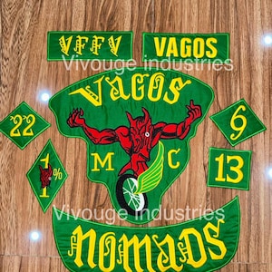 May include: A set of embroidered patches featuring green fabric with yellow lettering and red accents. The central patch displays a red devil figure on a motorcycle with the text VAGOS MC. Other patches include VFFV, VAGOS, NOMADS, 22, 6, 13, and 1%.