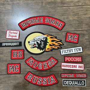 Puede incluir: Un conjunto de parches bordados con varios diseños y texto. Los parches presentan un lobo con llamas, las palabras "Moscú", "Rusia", "Filthy Few" y "Hardcore Inc". Los parches son rojos, negros y blancos.