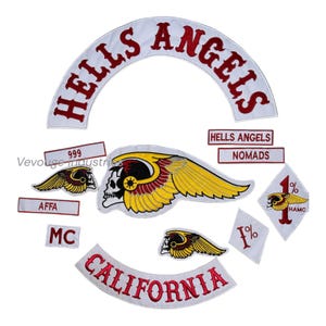 May include: A collection of white and red embroidered patches featuring the words "HELLS ANGELS" and "CALIFORNIA". Other patches include "999", "AFFA", "MC", "NOMADS", and a skull with wings.