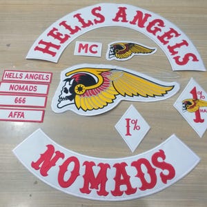 Könnte beinhalten: Eine Sammlung gestickter Aufnäher mit den Wörtern "HELLS ANGELS" und "NOMADS" in Rot auf weißem Hintergrund. Weitere Aufnäher zeigen einen geflügelten Totenkopf, die Buchstaben "MC", "666", "AFFA" und "1% HAMC".