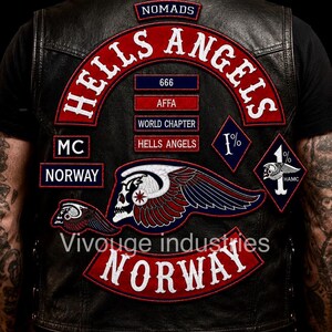 May include: A black leather vest featuring embroidered patches including the text Hells Angels, Nomads, World Chapter, AFFA, 666, MC, and Norway. The back displays a large winged skull emblem, a diamond-shaped 1% patch, and the text Vivouge industries.