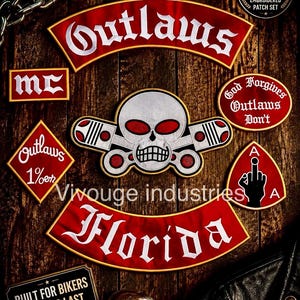May include: A set of embroidered patches featuring a central skull with crossed pistons, a large red Outlaws rocker, a Florida rocker, an MC patch, a God Forgives Outlaws Don't patch, a 1%er diamond patch, and a patch with a hand gesture.