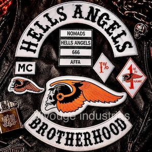 May include: A collection of embroidered patches on a black leather surface. The patches include a large arched HELLS ANGELS rocker, a BROTHERHOOD rocker, a winged skull emblem, and smaller rectangular patches reading NOMADS, HELLS ANGELS, 666, and AFFA.