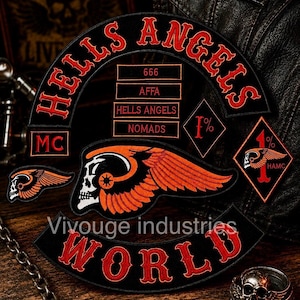 May include: A black and red embroidered patch set featuring the text HELLS ANGELS, MC, 666, AFFA, NOMADS, 1%, and WORLD. The design includes a winged skull emblem, a diamond-shaped 1% patch, and a smaller winged skull patch with orange accents.