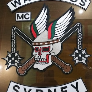 May include: Embroidered patch set featuring the text "WARLORDS" and "SYDNEY". The central design includes a skull with crossed clubs, wings, and flails. The patch set is black, white, red, green, and brown.