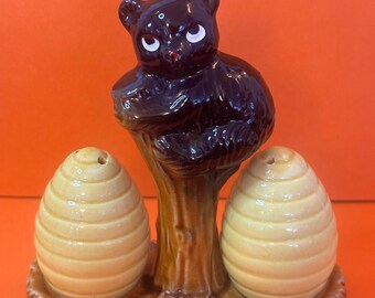 Juego de salero y pimentero de cerámica vintage de los años 70 con la figura de un oso sentado sobre un tocón de árbol, fabricado en Japón.