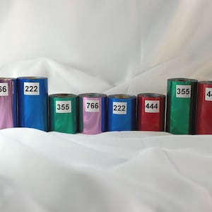 May include: Eight cylindrical rolls of metallic foil in various colors including pink, blue, green, and red. Each roll features a white rectangular label with a black numerical code: 766, 222, 355, 766, 222, 444, 355, and 444, arranged in a row.