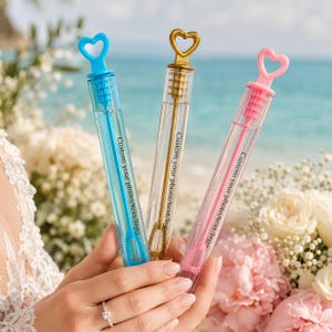 Può includere: Tre bacchette per bolle di sapone in plastica trasparente con manici a forma di cuore in blu, oro e rosa. Ogni tubo presenta il testo stampato Custom your photo/text/logo e contiene una bacchetta colorata abbinata per fare bolle.