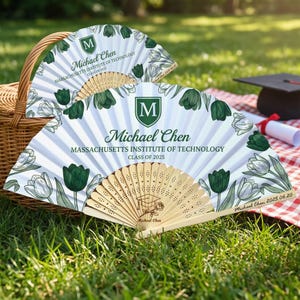 May include: A white ceramic mug with a black handle and the text "But First, Coffee" in a bold, black font. The mug is set against a blurred background, suggesting a cozy setting.