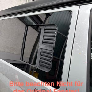 Könnte beinhalten: Nahaufnahme eines Fahrzeugfensters mit einem installierten schwarzen, rechteckigen Lüfter. Der Lüfter hat horizontale Lamellen und ist vor einer reflektierenden Glasscheibe angebracht. Der Text im Bild lautet: "Bitte beachten Nicht für das Original Fenster!"