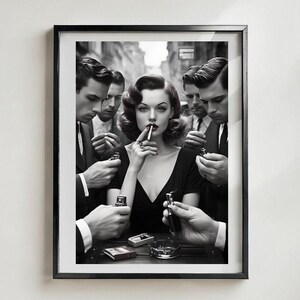 May include: Black and white framed print featuring a woman in a black dress smoking a cigarette, surrounded by men holding lighters. The image has a vintage, film noir aesthetic, with a focus on the woman's face and the surrounding figures.
