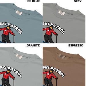 May include: Four t-shirts in ice blue, grey, granite, and espresso colors. Each shirt features the text "SKI PATROL" above a graphic of a skier in a red jacket and black pants.