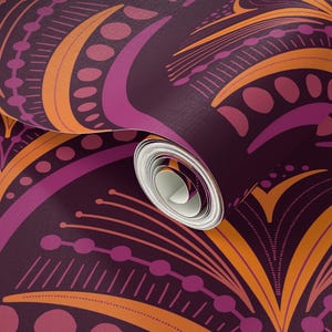 Puede incluir: Un rollo de papel pintado con un patrón abstracto repetitivo en tonos morado, naranja y rosa. El diseño presenta líneas curvas, puntos y elementos florales estilizados, creando una estética retro y artística.