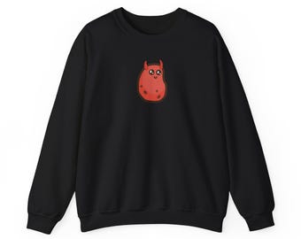 May include: Black sweatshirt featuring a red cartoon character with horns and spots. The character has a smiling face. The sweatshirt has a crew neck and long sleeves.