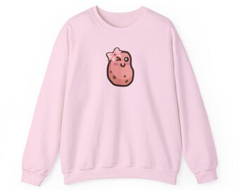 May include: A light pink sweatshirt featuring a cartoon potato character with a pink bow and winking eye. The potato has brown spots and a dark outline. The sweatshirt has long sleeves and a crew neck.