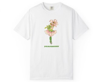 May include: A white short-sleeve t-shirt featuring a central graphic of a small figure dressed in a pink flower petal skirt and hat with green leggings. Below the illustration, the text potatoqueentv is printed in a bold green sans-serif font.