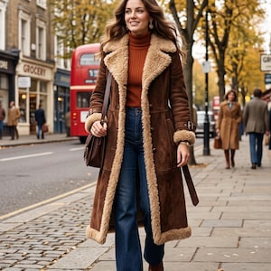 May include: A long brown suede coat with a thick beige shearling lining, collar, and cuffs. The coat is worn over a rust-colored ribbed turtleneck sweater and dark blue flared denim jeans. A brown leather shoulder bag and brown platform shoes.