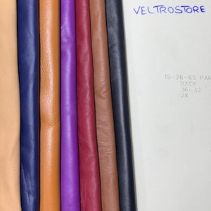 May include: A collection of colorful leather swatches in various shades, including tan, navy blue, orange, purple, burgundy, brown, and black. The image also shows the text "VELTROSTORE" and some additional text on a white background.