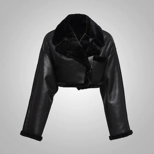 May include: A black cropped jacket with a faux fur collar and trim. The jacket has long sleeves and a classic design. The jacket has a smooth, leather-like texture, offering a stylish outerwear option.
