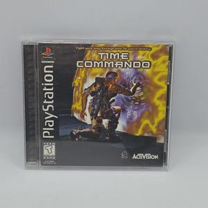 Könnte beinhalten: PlayStation-Spielhülle für "Time Commando". Das Cover zeigt einen futuristischen Soldaten, der kniet, vor einem feurigen Hintergrund. Der Titel des Spiels steht in fetten, weißen Buchstaben. Das PlayStation-Logo und das Activision-Logo sind ebenfalls sichtbar.