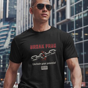 May include: Black t-shirt featuring the text "BREAK FREE" in red and white. A graphic of a broken chain with the word "FEARS" on one link is below the text. The phrase "Unchain your potential" is below the graphic.