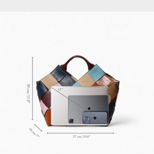 May include: A multi-colored leather tote bag with a woven design. The bag is 11.8 inches tall, 10.6 inches wide, and 7 inches deep. It has a brown handle and is shown with a laptop, tablet, and phone.