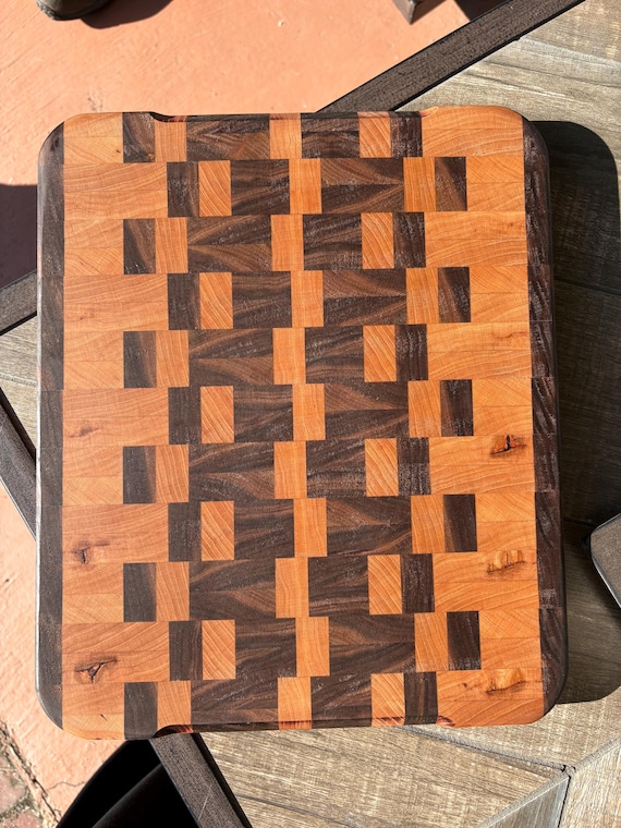 Two-tone walnut and cherry wood cutting board with natural contrast grain patterns that make it genuinely display-worthy on any countertop.