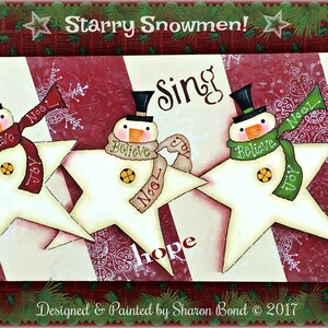 May include: A wooden Christmas sign featuring three snowmen holding stars. The snowmen are wearing hats and scarves. The sign has a red and white candy cane stripe design. The words "Starry Snowmen!" are at the top of the sign. The words "Wish", "Believe", "Sing", "Hope", "Love", "Dream" are written on the sign. The words "Designed & Painted by Sharon Bond © 2017" are at the bottom of the sign.