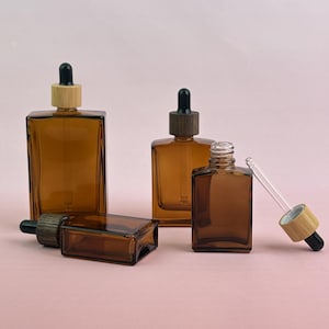 Envases cosméticos de vidrio ámbar vacíos con tapa de madera, frascos cuentagotas transparentes disponibles, diseñados para aceites esenciales, tónicos, perfumes y almacenamiento.