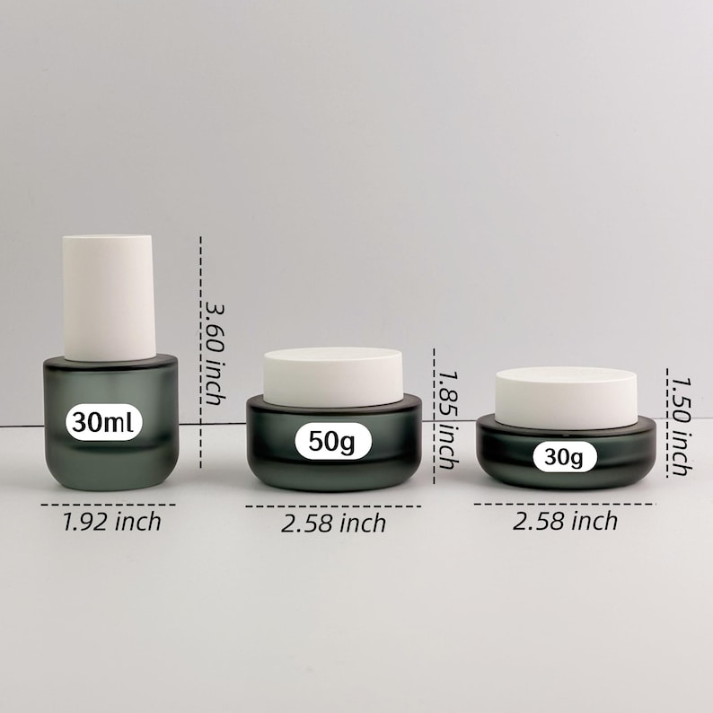 May include: Three cosmetic containers: a 30ml bottle (9.14 cm tall) and two jars, one 50g (4.70 cm) and one 30g (3.81 cm). All have a dark green base and white lids. The jars are 6.55 cm wide.