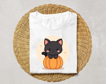 May include: White t-shirt featuring a cartoon black cat sitting on an orange pumpkin. The cat has pink ears and a cute expression. The design is set against a light yellow circle with small star accents, perfect for Halloween.