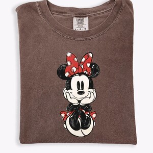 May include: A set of three ceramic mugs with a speckled, matte finish. The mugs are in shades of cream, light gray, and dark gray. Each mug has a simple, minimalist design and a rounded handle.