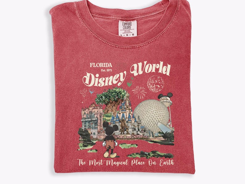 Puede incluir: Camiseta roja con un dise&ntilde;o de Disney World en Florida. El dise&ntilde;o incluye a Mickey Mouse, un castillo, Spaceship Earth y el texto "Florida Disney World" y "The Most Magical Place On Earth."
