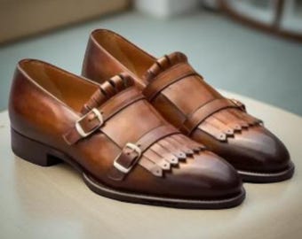 Botas de vestir elegantes de cuero marrón con doble hebilla y flecos para hombre.